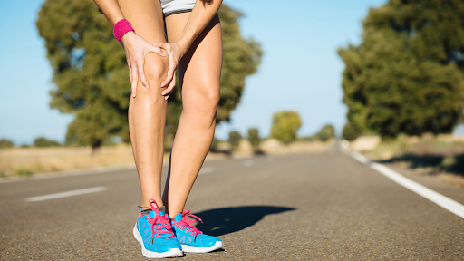 Athlete with joint discomfort mid-run, representing signs that call for chronic pain treatment in warmer months